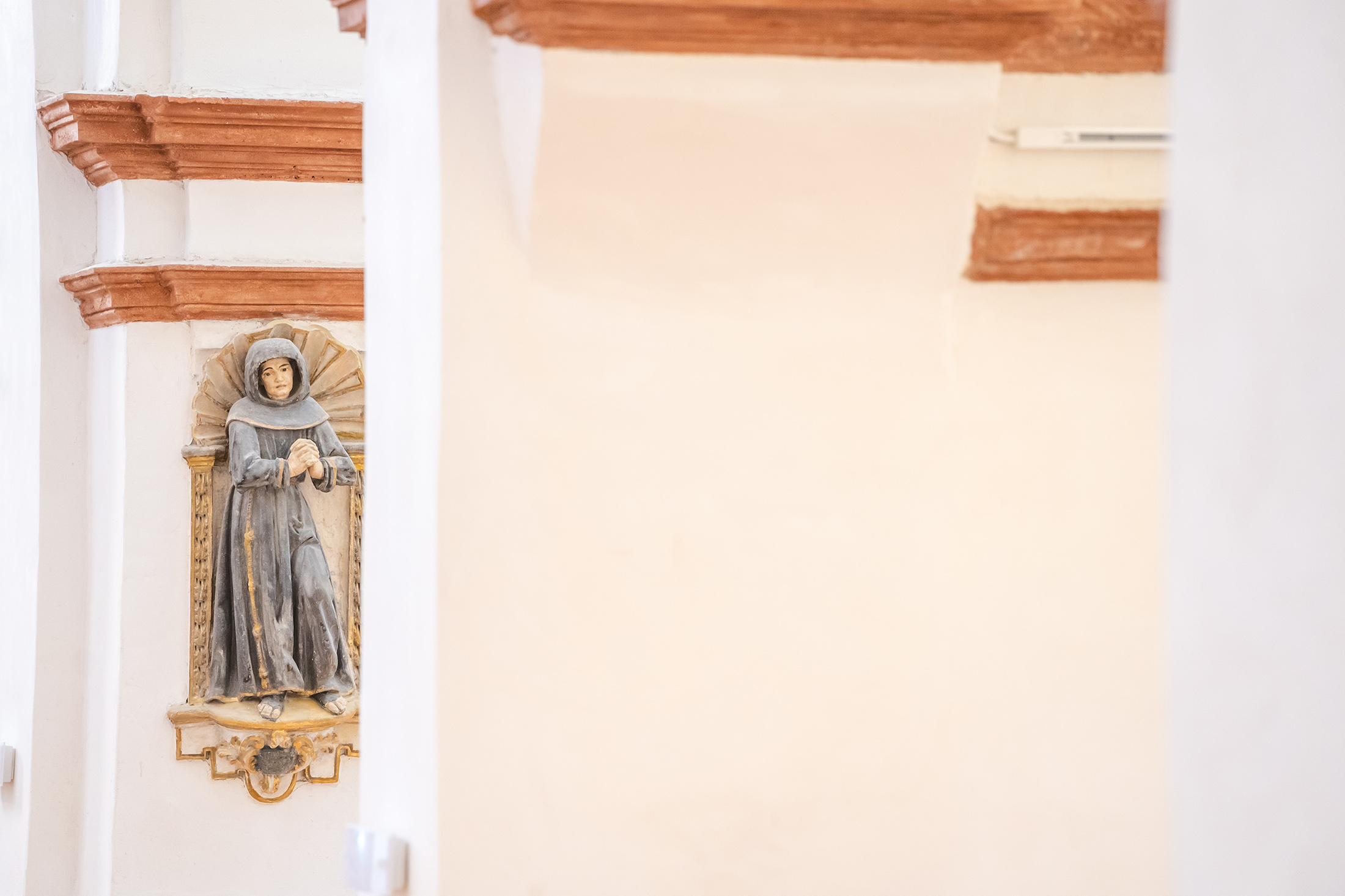 Hornacina restaurada en un pilar conservando una pequeña estatua religiosa